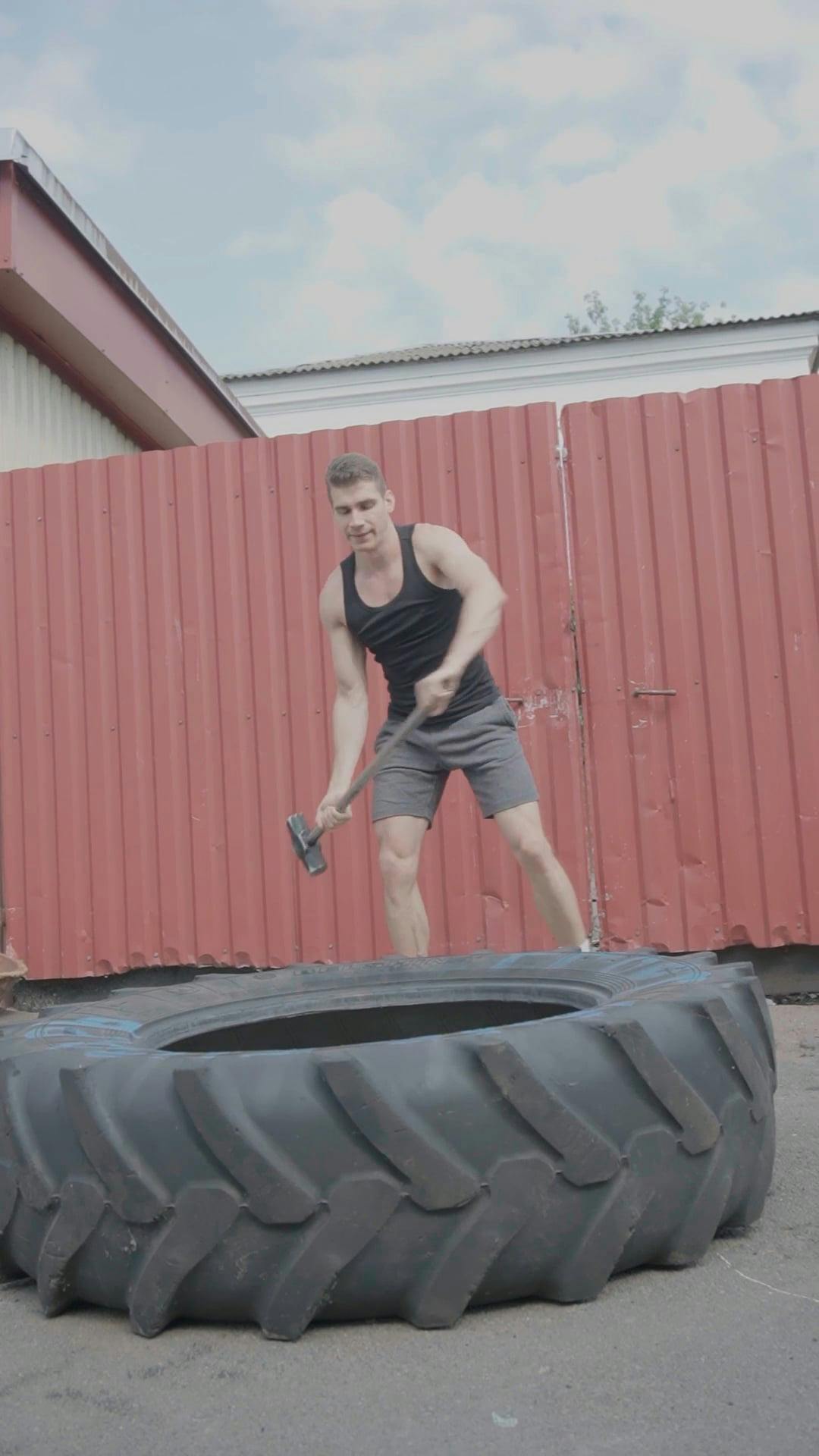A Man Hitting a Tire With a Sledgehammer · Free Stock Video