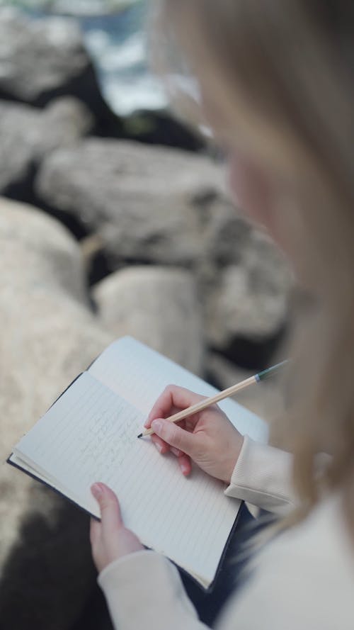 A Woman Writing on Her Notebook