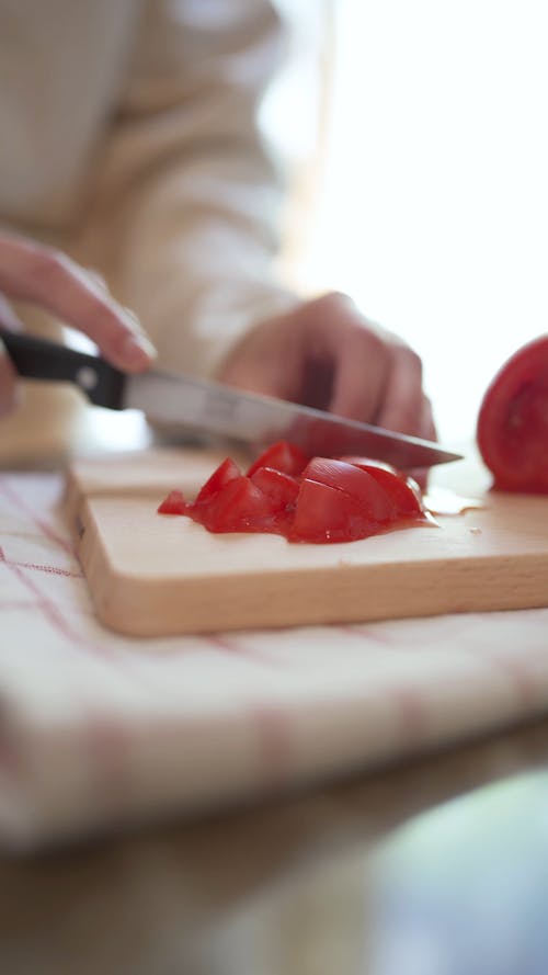 A Person Cutting a Tomato