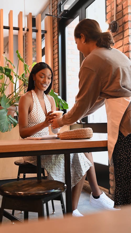 A Server Handing a Woman her Beverage