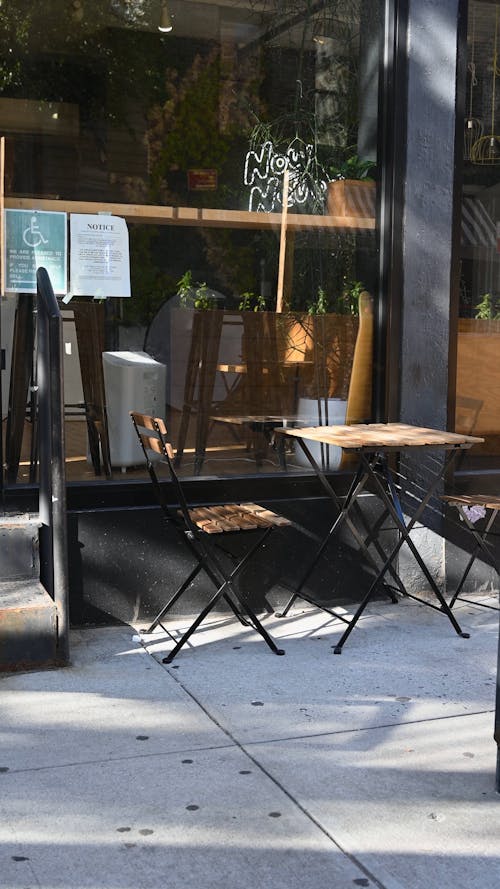 A Woman Putting a Menu Board Outside the Café