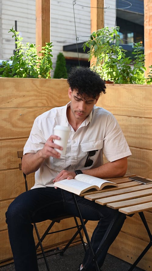 A Man Reading while Drinking Coffee