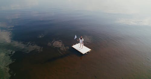 Drone Footage of a Woman Standing on a Raft