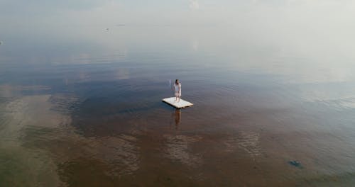 Drone Footage of a Woman Standing on a Raft