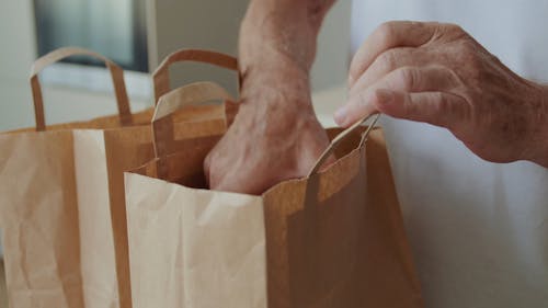 A Person Getting the Cherry Tomatoes Inside a Paper Bag