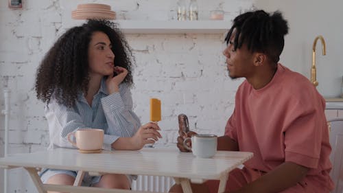 Couple Looking at each other while Eating Ice Cream