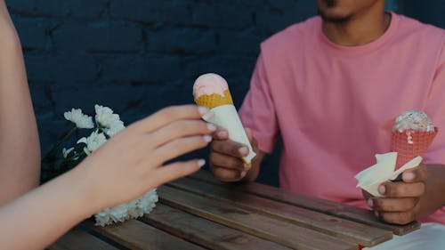 A Man Giving a Woman an Ice Cream in a Cone
