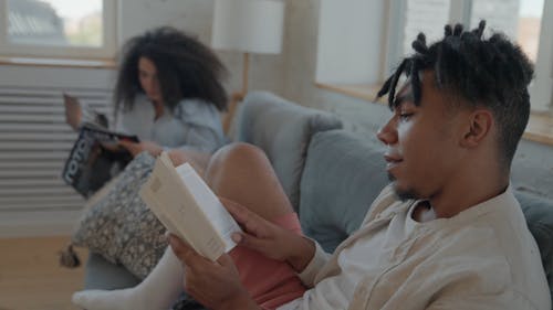 A Couple Reading While Sitting on a Couch