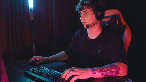 A Man Typing on Keyboard while Clicking the Mouse