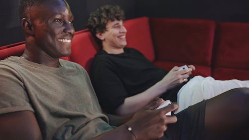 Men Playing Video Games while Sitting on a Sofa