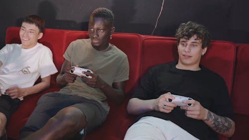 Men Sitting on a Sofa while Playing Video Games