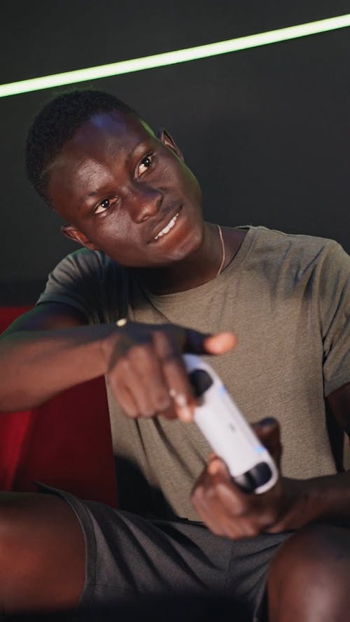 Man Sitting on Sofa Playing Video Game