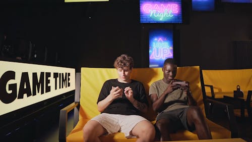 Men Using their Mobile Phones while Sitting on a Couch