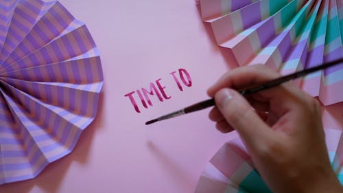 A Person Painting on a Pink Paper