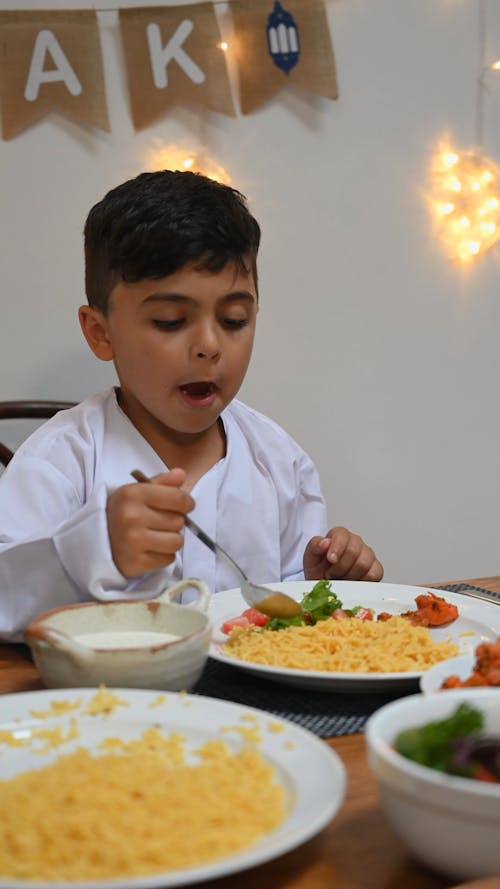 A Young Boy Eating Yellow Rice