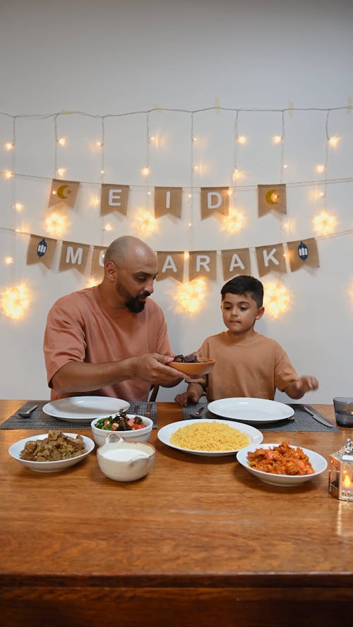 Man and Boy Eating Together while Celebrating Holiday 