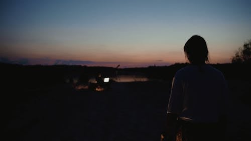 A Woman Walking Towards a Man During Night Time 