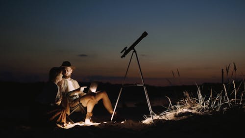 A Man and a Woman Using a Laptop Outdoors 