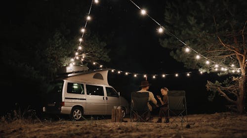 Back View of a Couple Sitting and Talking at a Campsite