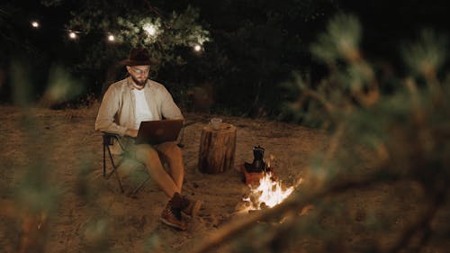 A Man Using his Laptop at a Campsite