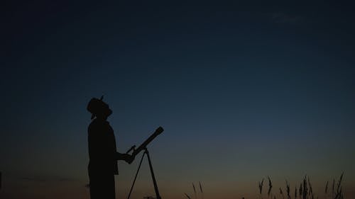 Silhouette of a Man and a Telescope 