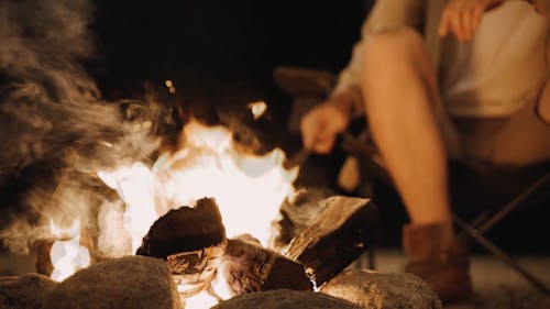 Person Sitting Near Campfire