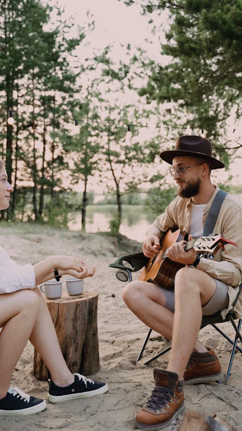 A Man Playing Guitar and Singing to a Woman