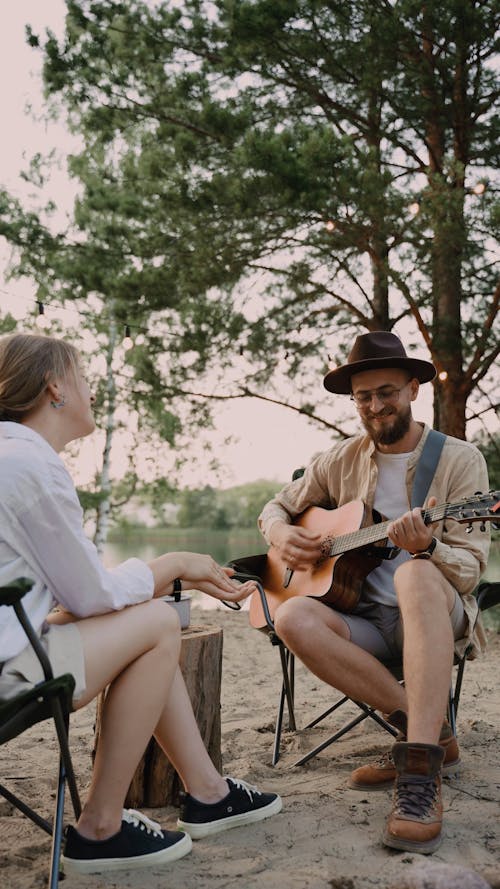 A Man Playing Guitar and Singing to her Partner