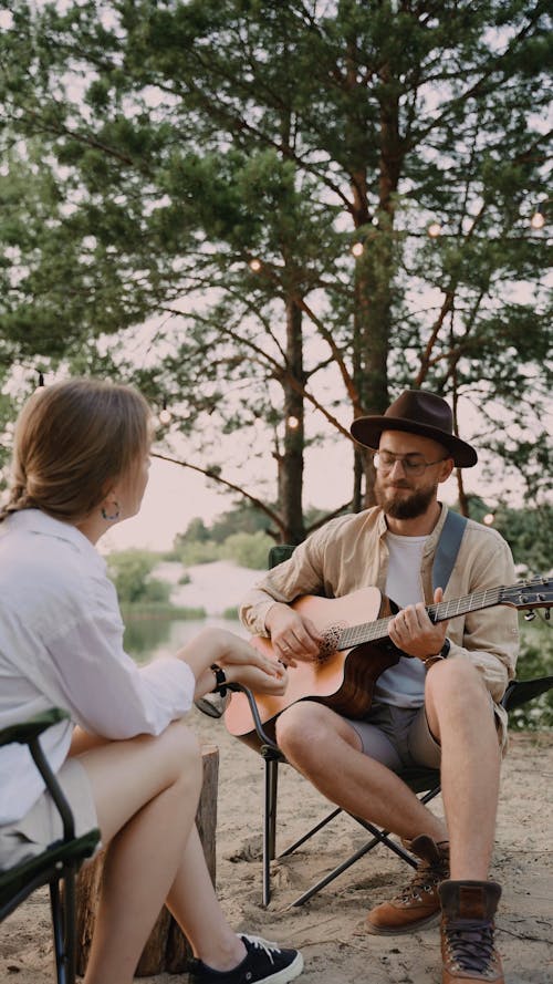 Man Playing Guitar and Singing a Song to her Partner