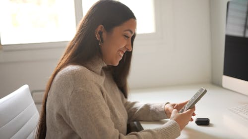 Woman Laughing While Using a Cellphone