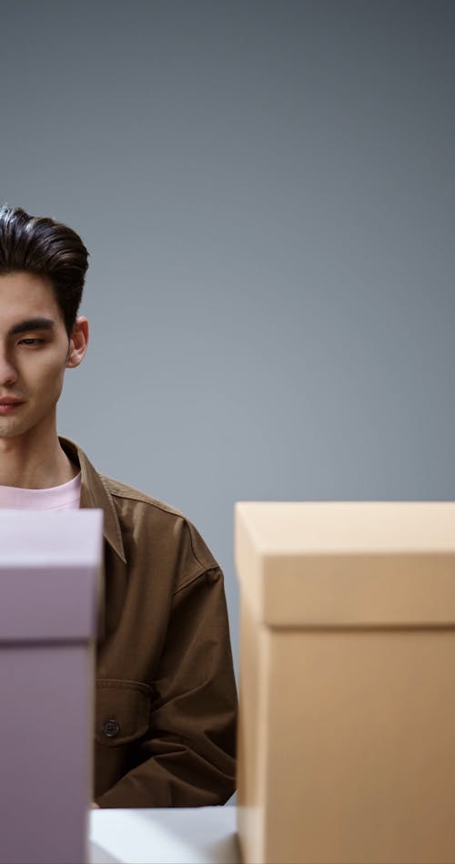 Man Putting a Paper Plane Inside a Gift Box