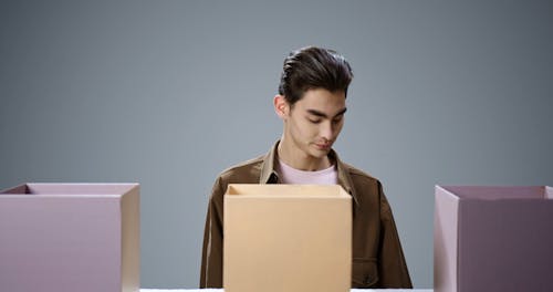 A Man Putting Things Inside the Boxes