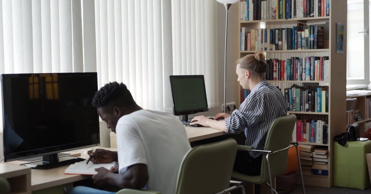 Students Researching on a Book and on a Computer Free Stock Video ...