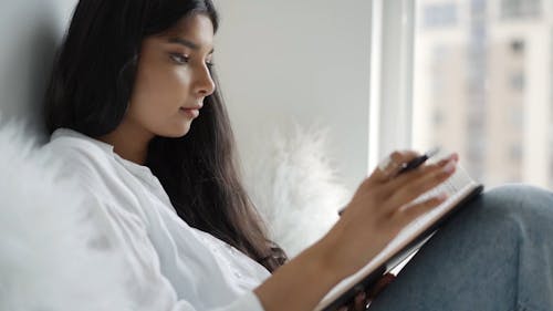 Woman Writing on a Notebook