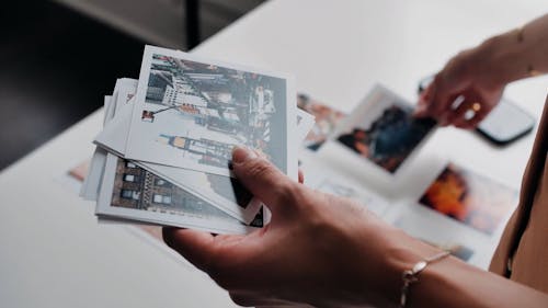 A Person Holding Printed Photographs