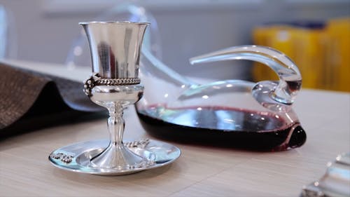Silver Plated Glass and a Pitcher of Wine on a Surface