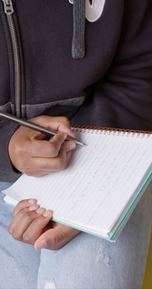 Person Writing On a Notebook