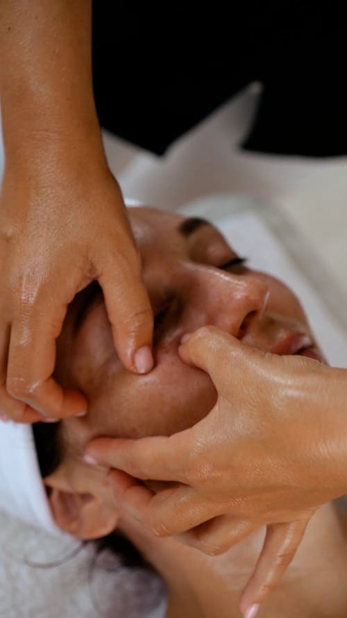 A Person Massaging a Woman's Face