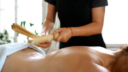 Massaging a Woman's Back by Sticks