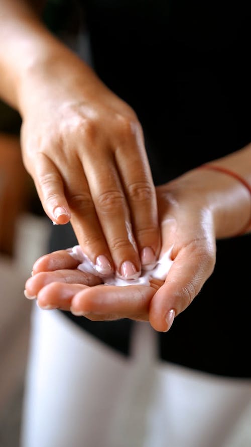 A Person Rubbing a Cream on It's Palm