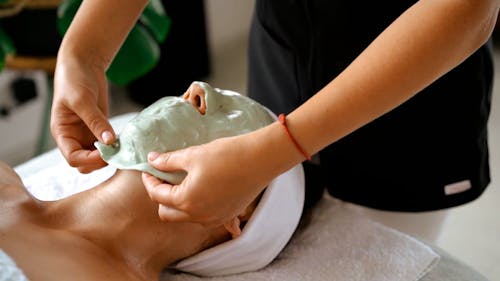 A Person Removing the Face Mask on a Woman's Face