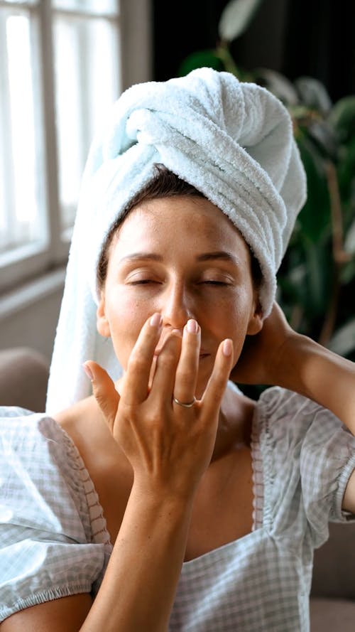 Woman Putting on Facial Care