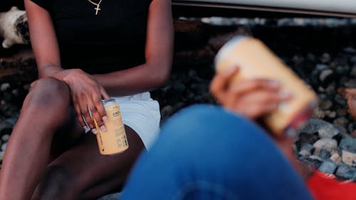 People Holding a Can of Beverage