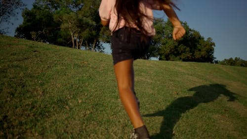 Back View of a Girl Running Uphill