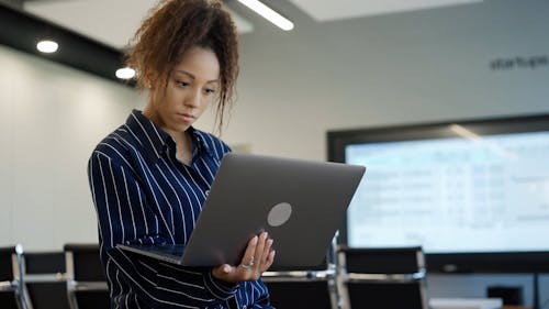 A Businesswoman Using a Laptop at an Office