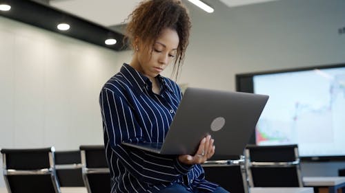 A Businesswoman Using a Laptop at an Office