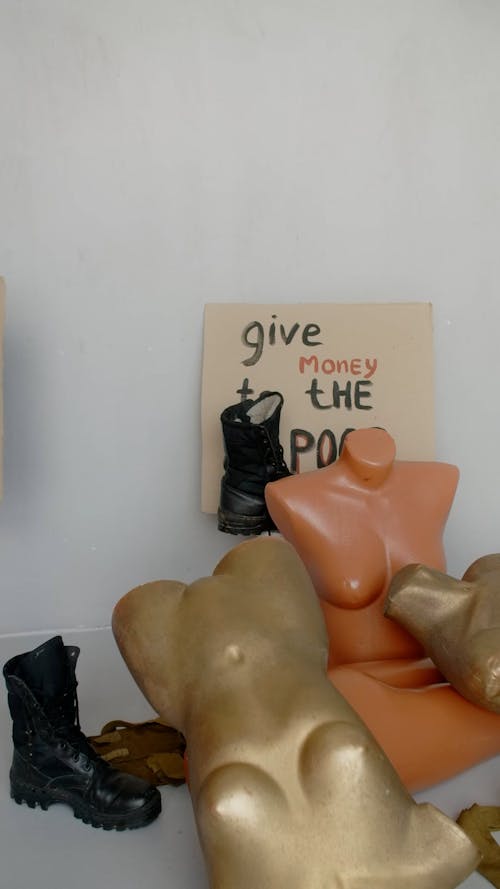 Person Putting a Placard Behind a Mannequin