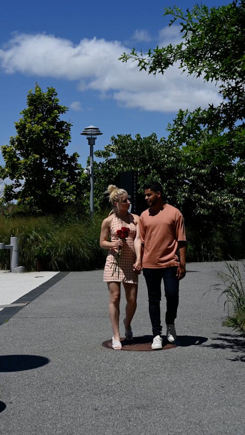 A Couple Holding Hands While Walking 