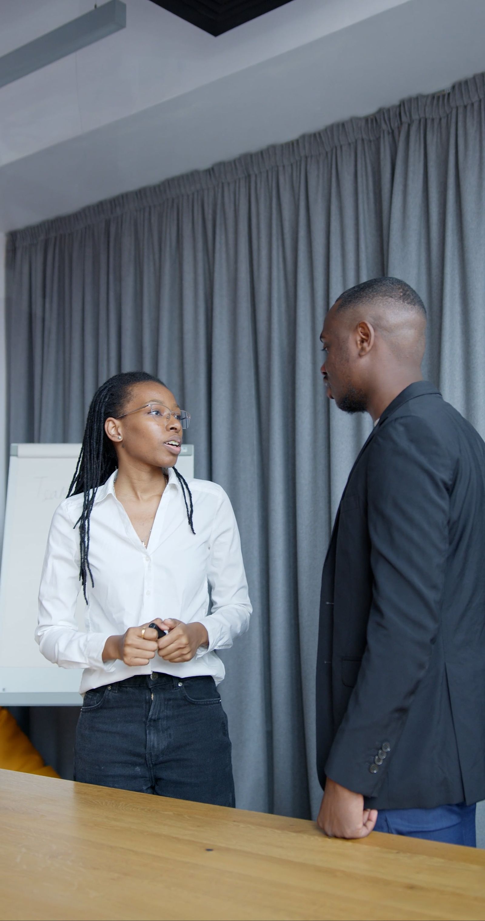 Black African professionals — a man and a woman — collaborating in a business meeting