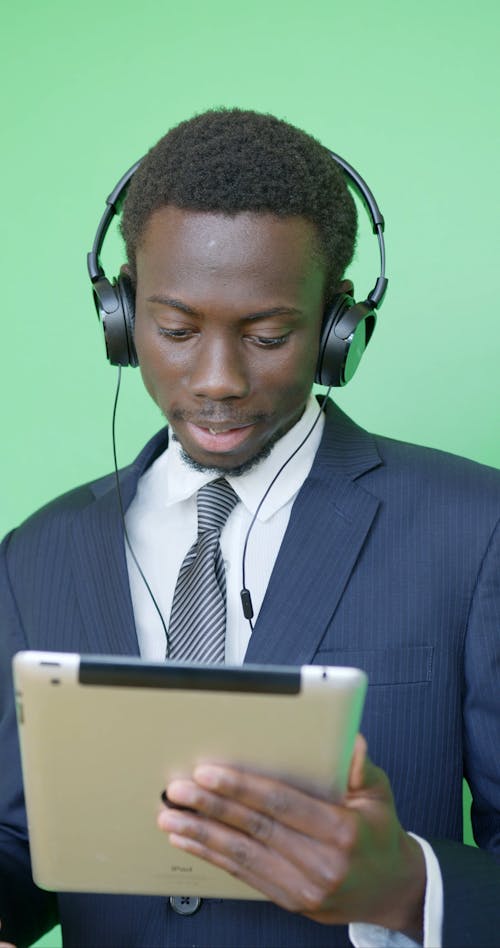 Man Wearing Headphones Using a Tablet